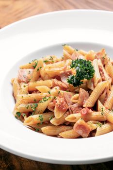 penne amatriciana tomato and ham sauce pasta on wood table background