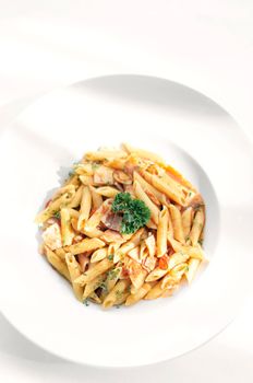 penne amatriciana organic tomato and ham sauce pasta dish on white table