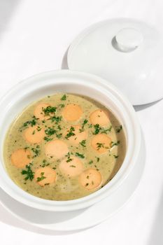 German traditional KARTOFFELSUPPE potato and sausage soup on white tabel background