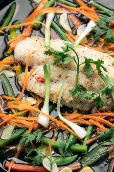 chinese cantonese style steamed spicy fish fillet with vegetables on hot plate