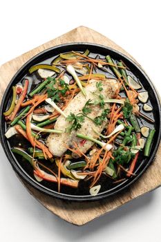 chinese cantonese style steamed spicy fish fillet with vegetables on hot plate