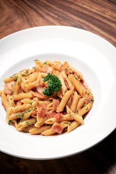 penne amatriciana tomato and ham sauce pasta on wood table background