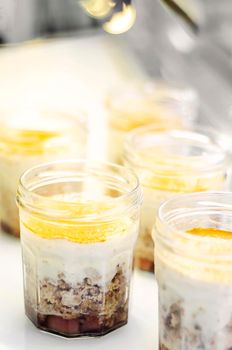 organic apple and coconut vegan cheesecake dessert in glass jam jar in cafe display