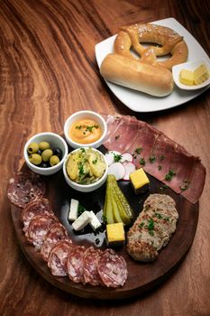 german cold cuts tapas snack platter with meats and bread on wood table background