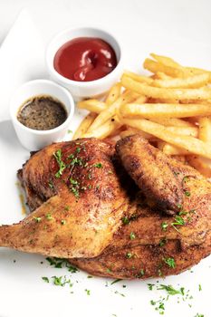 roast rotisserie half chicken with french fries simple meal on white plate