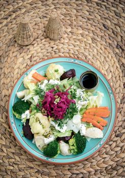 rustic cottage salad with healthy mixed steamed and fresh vegetables on colorful plate