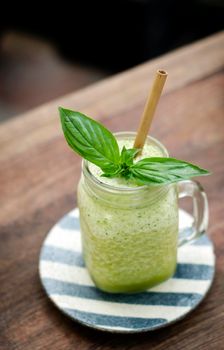 organic pineapple kiwi and basil fruit detox healthy smoothie drink outdoors in glass