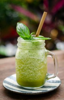 organic pineapple kiwi and basil fruit detox healthy smoothie drink outdoors in glass