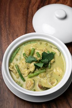 thai green curry with chicken and vegetables on wood table