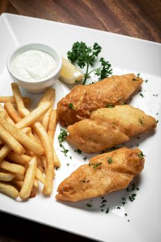 british traditional fish and chips meal on classic wood table