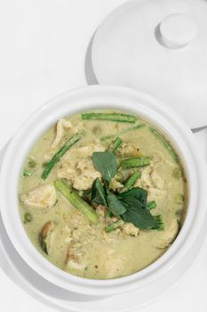 thai green curry with chicken and vegetables on white table background