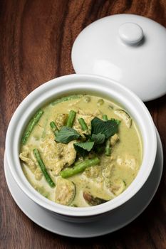 thai green curry with chicken and vegetables on wood table