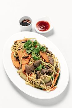 traditional khmer spicy beef stir fry with egg noodles and vegetables in cambodia on white studio background