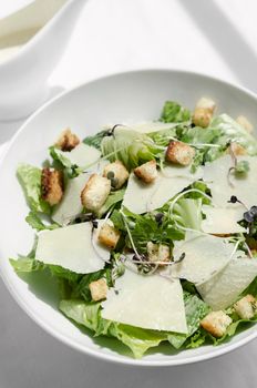 caesar salad with parmesan cheese and croutons on restaurant table
