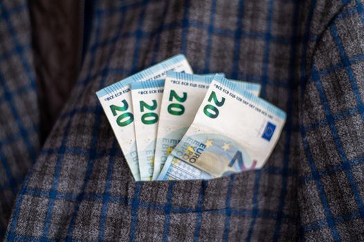 pocket of the plaid jacket coming out of 20 euro bills