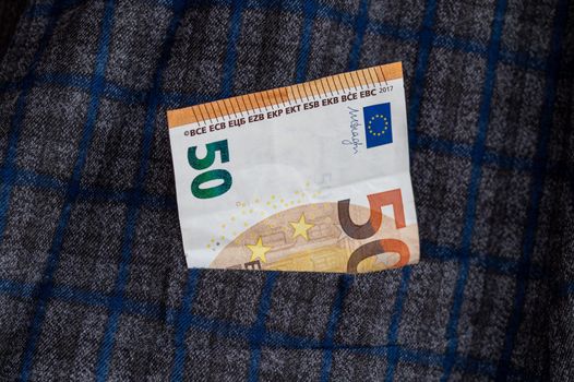 pocket of the plaid jacket coming out of 50 euro bills