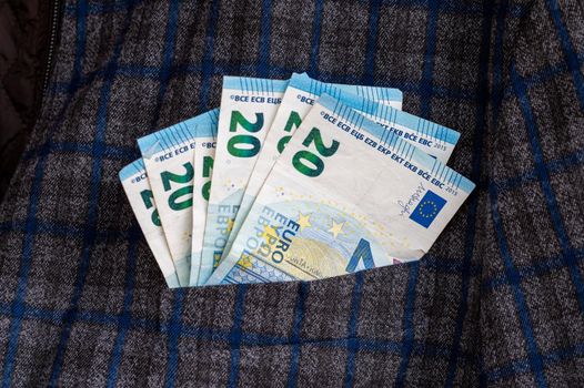 pocket of the plaid jacket coming out of 20 euro bills