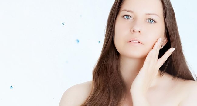 Rejuvenation skincare and beauty ad, beauty face portrait of young woman with healthy clean skin, blue cosmetic liquid drops on background.