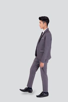 Young asian business man in suit walking movement isolated on white background, portrait of executive or manager, happy businessman handsome and smart, male with confident for success in studio.