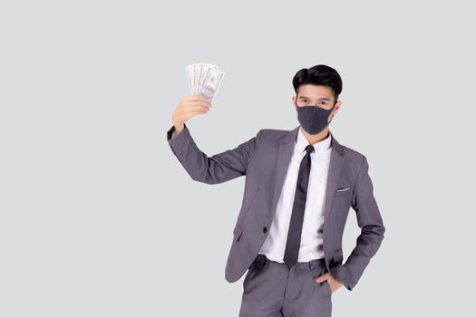 Young asian businessman in face mask holding money dollar isolated on white background, pandemic and crisis of economic, business man in medical mask and investment during disease covid-19.