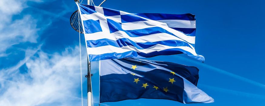 European political news, grexit and nation concept - Flags of Greece and European Union on blue sky background, politics of Europe