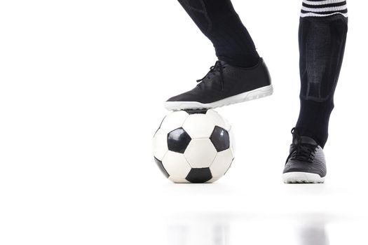 Soccer ball under soccer player's feet, isolated on white background