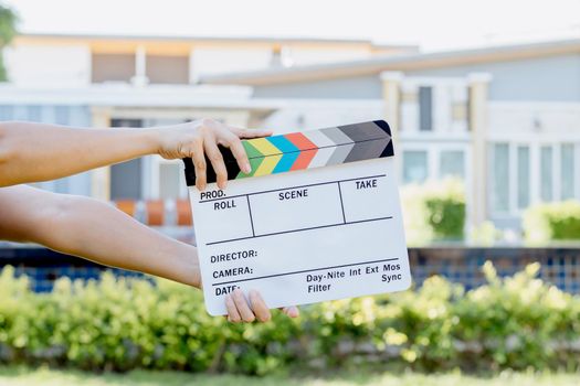 Hand holding film slate colors board for movie cinema and television industry on green background