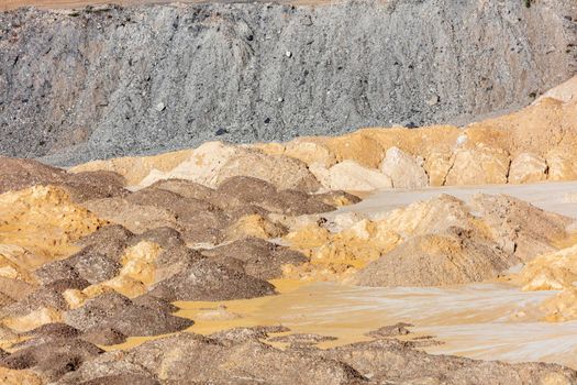 Photograph of crushed sand and stone laying on the ground in a large quarry