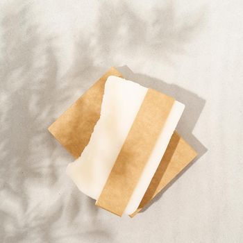 Natural organic cosmetics. Top view of handmade soap with craft blank band on white textured background with a shadow