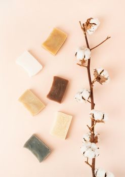Natural cosmetics. composition with various soap and cotton branch, natural cosmetics on beige background, top view flat lay