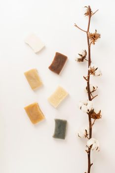 Natural cosmetics. composition with various soap and cotton branch, natural cosmetics on white background, top view flat lay