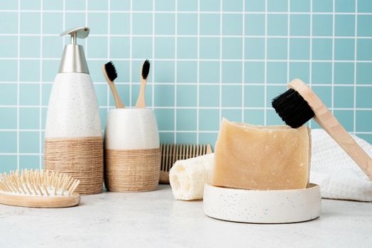 Bath accessories with bamboo brushes, handmade soap, dispenser and natural brushes on bath shelf, front view