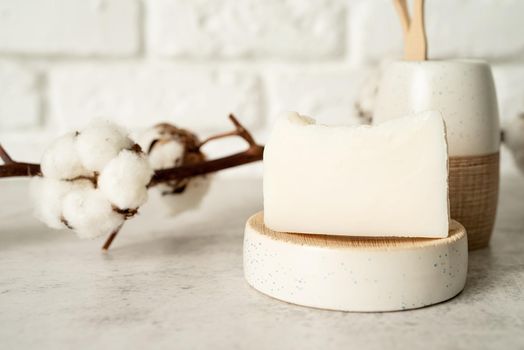 Bath accessories with bamboo brushes and handmade soap on bath shelf, front view