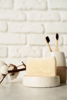 Bath accessories with bamboo brushes and handmade soap on bath shelf, front view