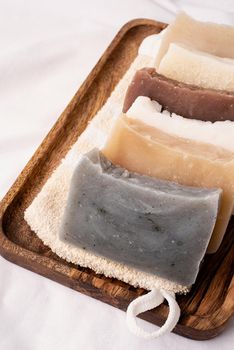 Natural organic cosmetics. Stack of hand made soap in wooden tray on white background