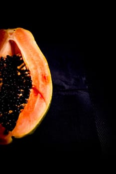 Half of an open papaya with the seeds. No people