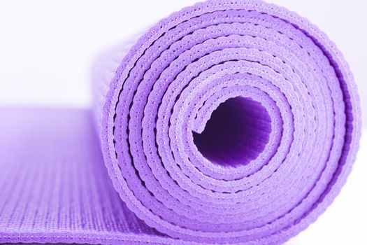 Rolled up yoga or pilates mat. No people