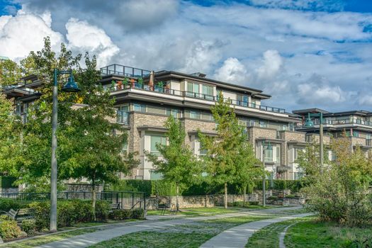 Residential apartment building on cloudy sky background.