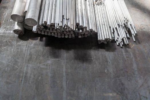 aluminium round long products on black steel surface.