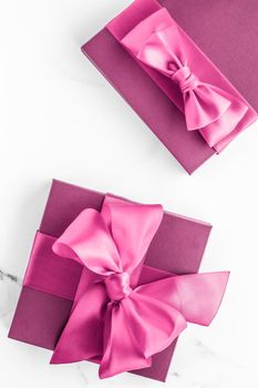 Birthday, wedding and girly branding concept - Pink gift box with silk bow on marble background, girl baby shower present and glamour fashion gift for luxury beauty brand, holiday flatlay art design