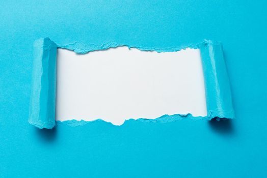 Tear on sheet reveals background behind the front side
