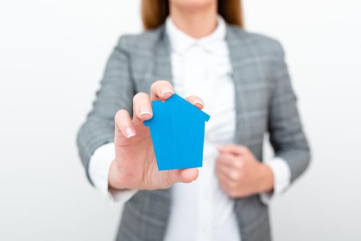 A Young Lady Businesswoman Holding Presenting Home In Business Outfit