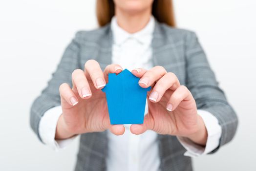 A Young Lady Businesswoman Holding Presenting Home In Business Outfit