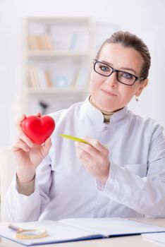 Cardiologist with red heart in medical concept