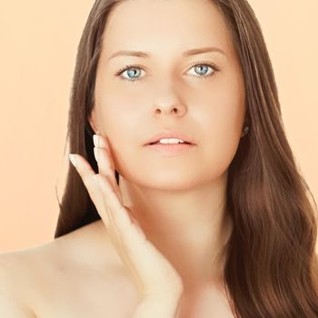 Sunny face portrait of young woman, suntan skin tone and beauty cosmetics. Beautiful brunette female model with natural tan using sunscreen product.