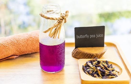 Butterfly pea juice is placed in a wooden tray with dried butterfly pea flowers. Thai herbs for health 