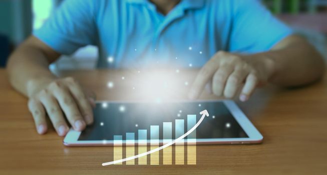 The hand of an enterprise employee using a tablet to analyze business data. Corporate growth concept Development and creation of sustainable goals.