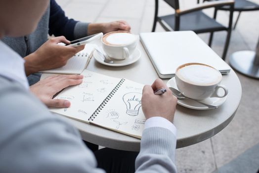 Two cheerful asian business people discussing with documents