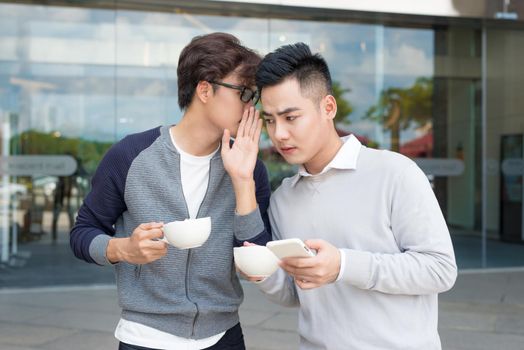 Closeup portrait of guy whispering into man's ear telling him something secret