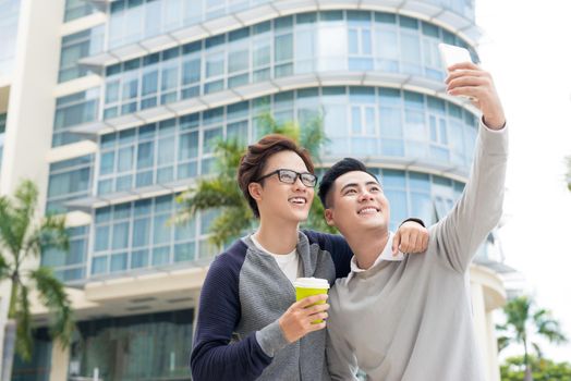 Two Vietnamese men traveler taking selfie in foreign city